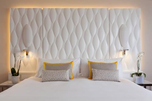 a bedroom with a large white bed with two pillows at Renaissance Aix-en-Provence Hotel in Aix-en-Provence