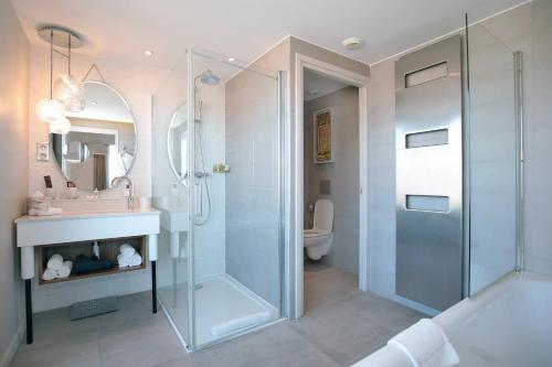 a bathroom with a shower and a sink and a toilet at Renaissance Aix-en-Provence Hotel in Aix-en-Provence