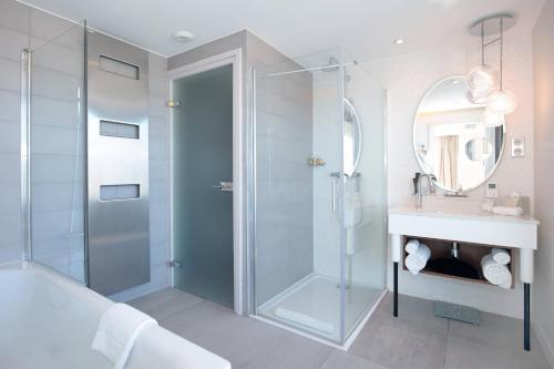 La salle de bains est pourvue d'une douche en verre et d'un lavabo. dans l'établissement Renaissance Aix-en-Provence Hotel, à Aix-en-Provence