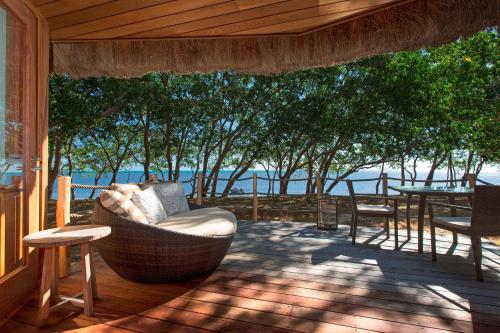 a porch with a couch and a table and chairs at Sheraton New Caledonia Deva Spa & Golf Resort in Bourail
