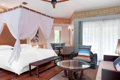 a hotel room with a bed and a table at Sheraton New Caledonia Deva Spa & Golf Resort in Bourail