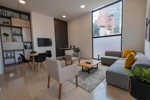 salon z kanapą i stołem w obiekcie Acogedor loft en Centro Internacional de Bogotá w mieście Bogota