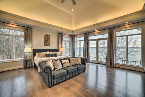 1 dormitorio con cama, sofá y ventanas en Spacious Lakefront Kentucky Home Rental!, en Cadiz