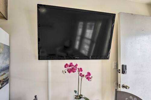 a flat screen tv hanging on a wall with a flower at Brigantine Vacation Rental - Walk to Beach! in Brigantine