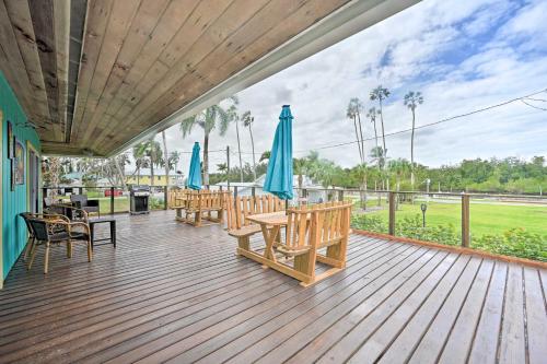 a wooden deck with chairs and umbrellas on it at Everglades Getaway with Deck and Water Views! in Everglades City