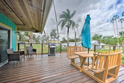 a wooden deck with a table and chairs and an umbrella at Everglades Getaway with Deck and Water Views! in Everglades City