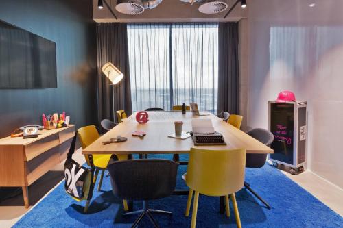 a conference room with a table with chairs and a laptop at Moxy Amsterdam Houthavens in Amsterdam