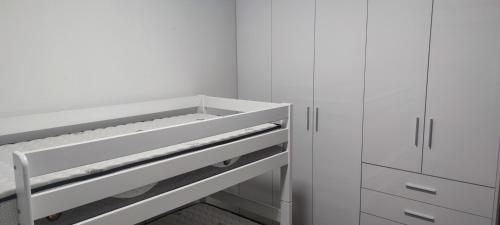 a white kitchen with white cabinets and a drawer at Iridium Apartment in Skopje