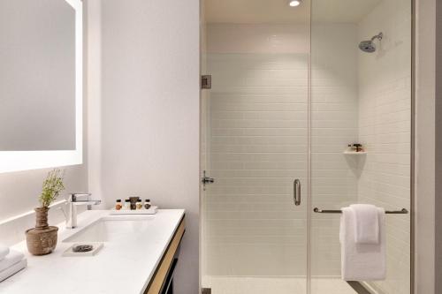 a bathroom with a shower and a sink at Cotton House, Cleveland, a Tribute Portfolio Hotel in Cleveland