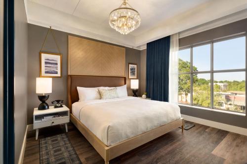 a bedroom with a bed and a large window at Cotton House, Cleveland, a Tribute Portfolio Hotel in Cleveland