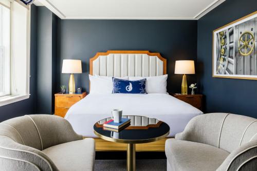 a bedroom with a bed with blue walls and two chairs at The National, Autograph Collection in Oklahoma City