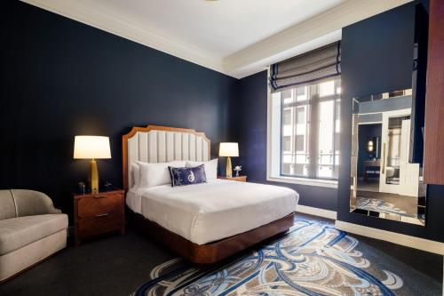 a bedroom with a bed and a couch and a window at The National, Autograph Collection in Oklahoma City