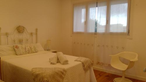 1 dormitorio con cama, ventana y silla en Preciosa Habitación Doble en Ático con Terraza II, en Santiago de Compostela