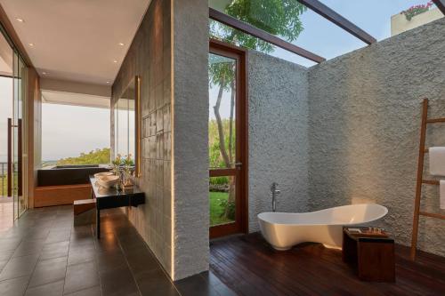 a bathroom with a tub and a large window at Renaissance Bali Uluwatu Resort & Spa in Uluwatu