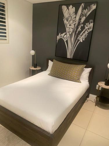 Un dormitorio con una cama blanca con una foto en la pared en 608 Beacon Rock, en Durban