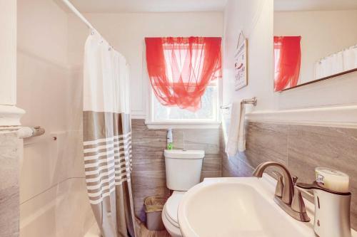 ein Bad mit einem Waschbecken, einem WC und einem Fenster in der Unterkunft Charming Laurel Home with Gazebo and Fireplace! in Delmar