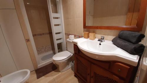 a bathroom with a sink and a toilet and a mirror at La Calma en Playa de Salinetas - cerca de playa y supermercado in Telde