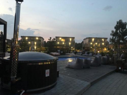 a large pool with white pillows and tables and buildings at ‘Audronė’ svečių namai in Palanga