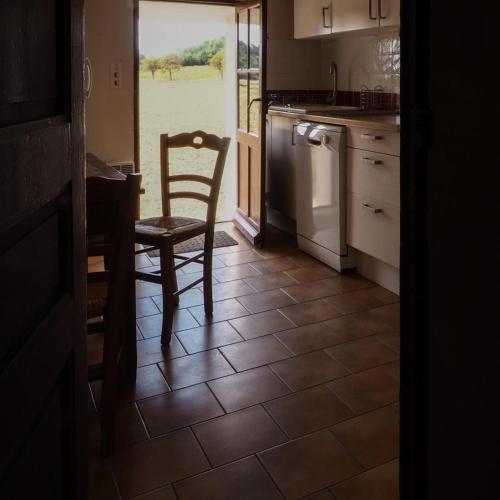 - une cuisine avec une chaise, une table et une cuisinière dans l'établissement Le moulin de saint ferreol, à Pontevès