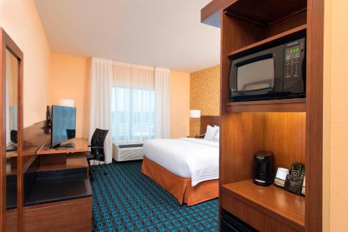 um quarto de hotel com uma cama e uma televisão em Fairfield Inn & Suites by Marriott Jackson Clinton em Clinton