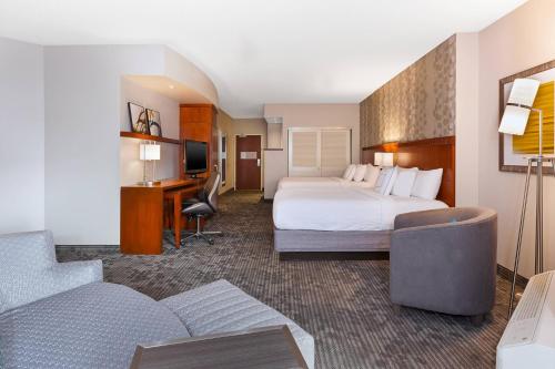 Courtyard by Marriott Oklahoma City Downtown في مدينة اوكلاهوما: غرفة الفندق بسرير ومكتب واريكة