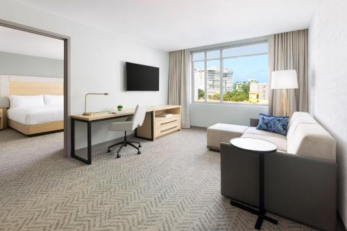 a hotel room with a bed and a desk and a bedroom at Residence Inn by Marriott San Juan Isla Verde in San Juan