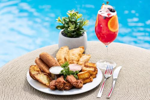 a plate of food and a drink next to a pool at Residence Inn by Marriott San Juan Isla Verde in San Juan