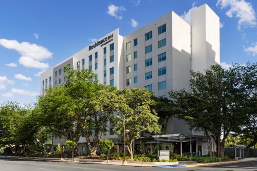 an office building with trees in front of a street at Residence Inn by Marriott San Juan Isla Verde in San Juan