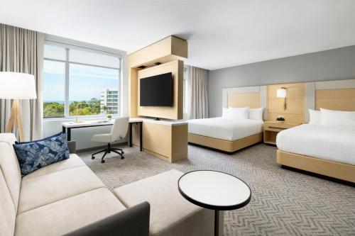 a hotel room with two beds and a couch at Residence Inn by Marriott San Juan Isla Verde in San Juan