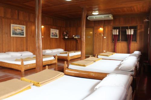 a room with four beds in a wooden room at Saengthong Resort Chiangmai in Chiang Mai