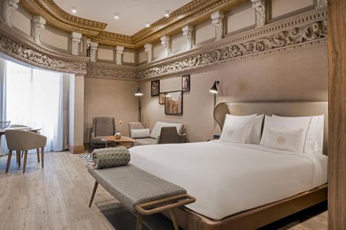 a bedroom with a large bed and a living room at Círculo Gran Vía, Autograph Collection (Adults Only) in Madrid