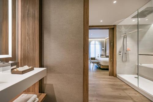 a bathroom with a tub and a shower and a sink at Círculo Gran Vía, Autograph Collection (Adults Only) in Madrid