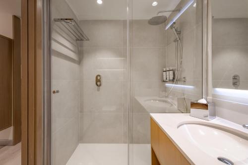 y baño con ducha y lavamanos. en AC Hotel by Marriott Saint-Julien-en-Genevois, en Saint-Julien-en-Genevois