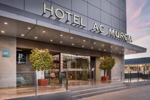 ムルシアにあるAC Hotel Murcia by Marriottのホテル mgm 目の前に鉢植えの木が2本あり
