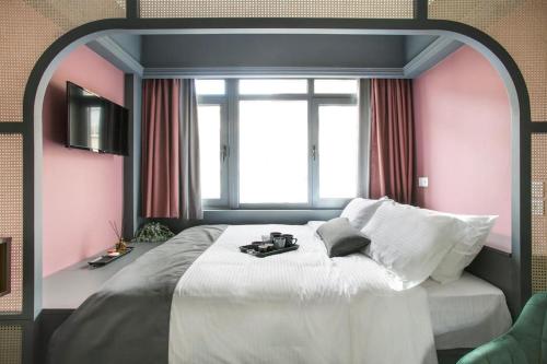 a bedroom with a large white bed with a window at Athens Luxury Rooms II in Athens