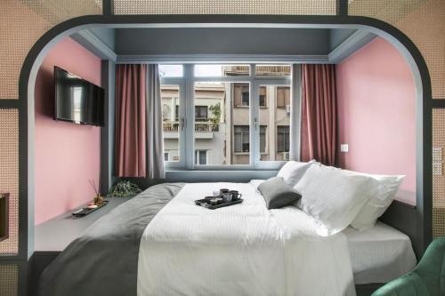Schlafzimmer mit einem großen Bett und einem Fenster in der Unterkunft Athens Luxury Rooms II in Athen