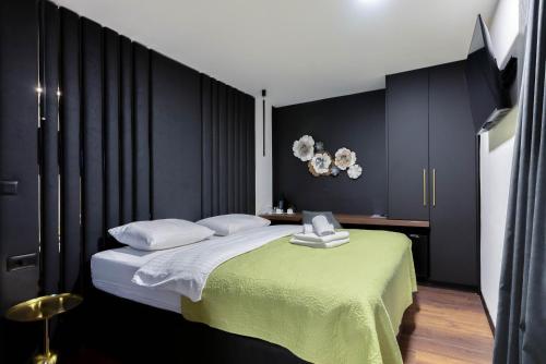 1 dormitorio con 1 cama grande y paredes negras en City Premium Rooms Old town, en Zadar