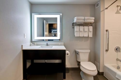 a bathroom with a sink and a toilet and a mirror at TownePlace Suites by Marriott Kincardine in Kincardine