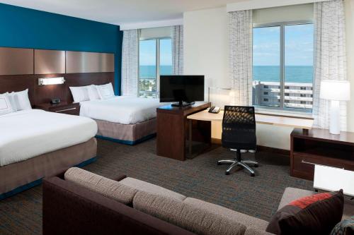 a hotel room with two beds and a desk at Residence Inn by Marriott Clearwater Beach in Clearwater Beach
