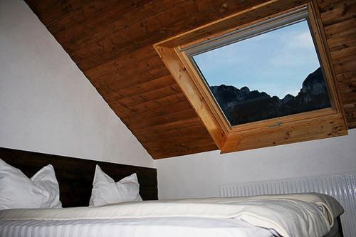 a bedroom with a bed with a large window at Taverna Pietrei Craiului in Zărneşti