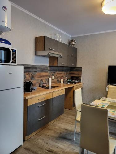 een keuken met houten kasten en een witte koelkast bij Guest house Sunny in Jūrmala