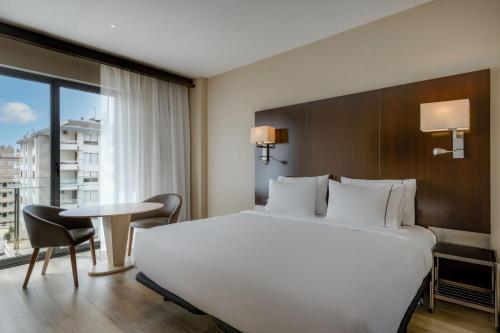 una habitación de hotel con una cama grande y una mesa en AC Hotel Ciutat de Palma by Marriott, en Palma de Mallorca