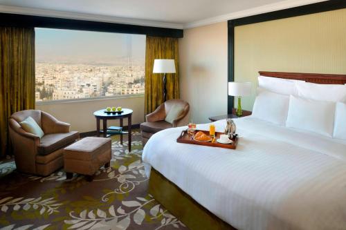 um quarto de hotel com uma cama e uma grande janela em Amman Marriott Hotel em Amã