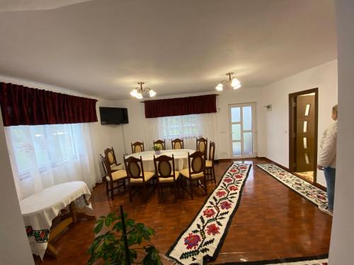 a dining room with a table and chairs and a television at Casa din Deal in Văleni