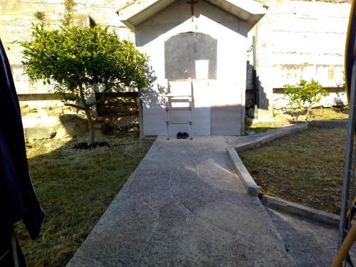 a dog is sitting in front of a small building at Marko in Podstrana