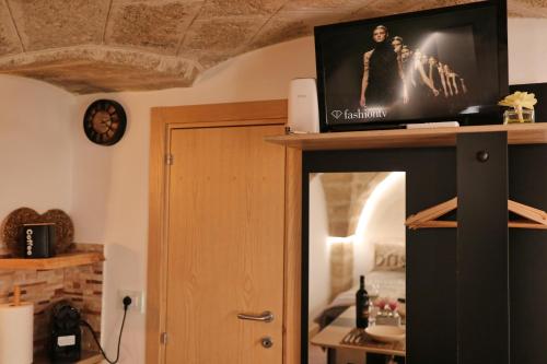 a living room with a tv on top of a cabinet at La dimora delle teresiane in Fasano
