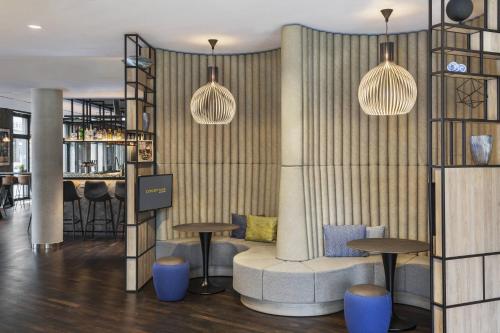 a bar with blue stools and two pendant lights at Courtyard by Marriott Hamburg City in Hamburg