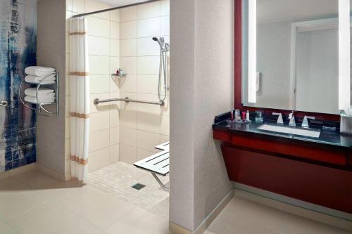 a bathroom with a shower and a sink and a mirror at Atlanta Airport Marriott Gateway in Atlanta