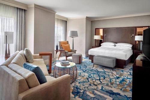 a hotel room with a bed and a living room at Atlanta Airport Marriott Gateway in Atlanta
