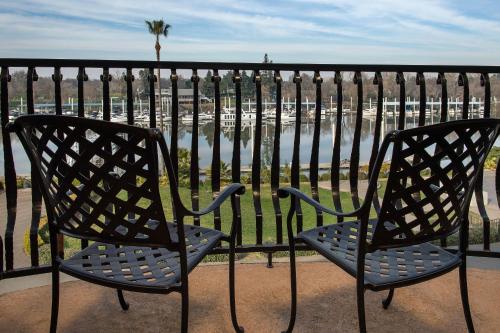 two chairs sitting on a balcony overlooking a body of water at The Westin Sacramento Riverfront Hotel & Spa in Sacramento